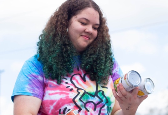 Girl holds cans of food