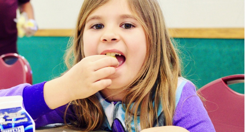Little girl eats a snack