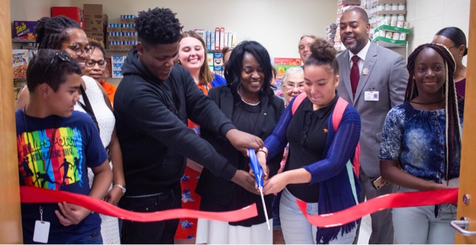 Students cut ribbon at a feeding minds school pantry