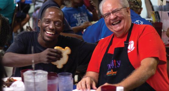 2 gentleman smile over a meal at Trinity Cafe