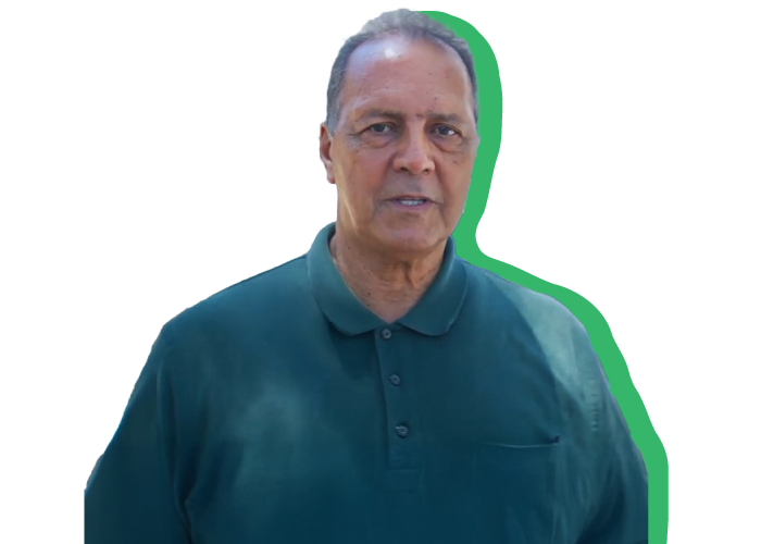 A headshot of Juan, a retired veteran, in a dark green buttoned up polo.