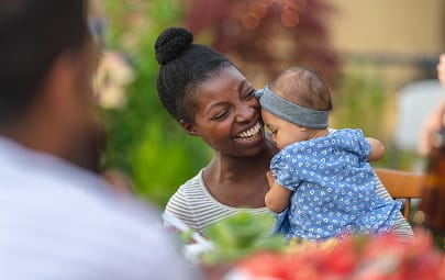 A mother holding her baby and laughing